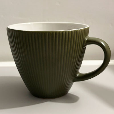 A dark green tapered shape ceramic mug with vertical ridges